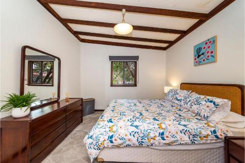 a bedroom with a bed and a dresser and a mirror at Rose Cottage Nannup in Nannup