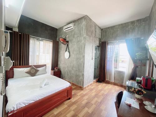 a bedroom with a large bed and a desk at Amy Hostel Hue in Hue