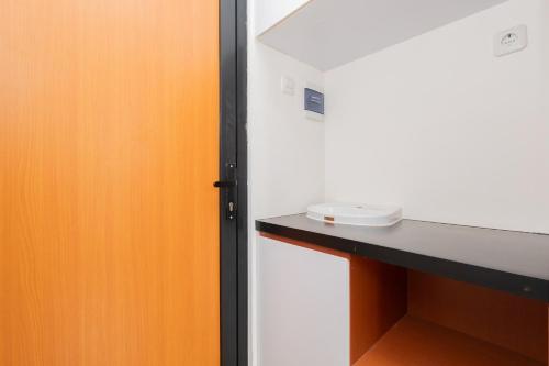 a room with an orange door and a counter at RedLiving Syariah Apartemen MKostel - Tower A1 Kencana Loka 