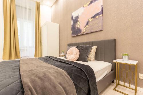 a bedroom with a bed and a painting on the wall at Deluxe Izabella Apartment in the Center of Budapest in Budapest