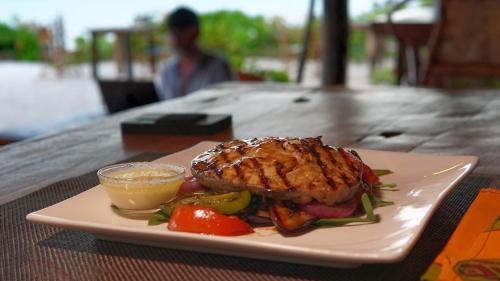 a plate of food with a sandwich on a table at Belvedere Resort in Jambiani