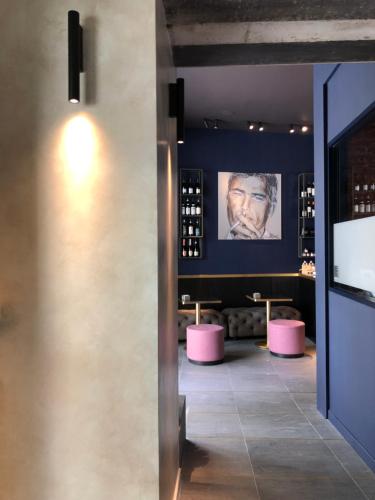 多莫多索拉的住宿－Palazzo 7，酒吧,有粉红色的凳子和一张男人的照片