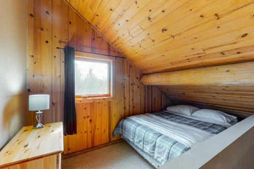 a bedroom with a bed in a wooden cabin at Lac Le Jeune at Cabin 29 and 30 in Kamloops