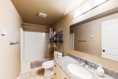 a bathroom with a sink and a toilet and a mirror at Lac Le Jeune at Cabin 29 and 30 in Kamloops