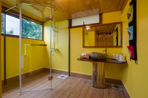 Łazienka z przeszkloną kabiną prysznicową i drewnianą podłogą w obiekcie Mai Chau Onsen Retreat w mieście Mai Châu