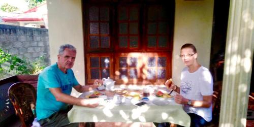 two men sitting at a table eating food at ARANI HOMESTAY in Polonnaruwa