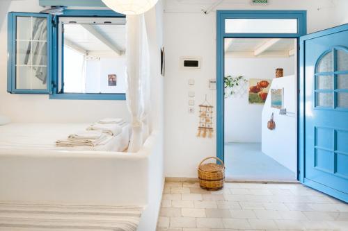 a bathroom with a blue door and white walls at Beachfront Lampis Dolphin 1 in Skala
