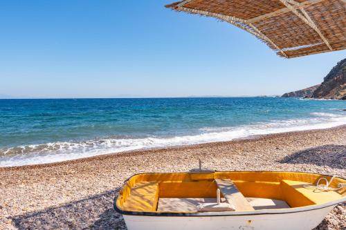 a yellow boat sitting on a beach next to the ocean at Beachfront Lampis Dolphin 1 in Skala
