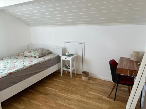 ein Schlafzimmer mit einem Bett, einem Tisch und einem Stuhl in der Unterkunft Lichtdurchflutete 90 m2 drei Zimmer Duplexwohnung in Altperlach in München