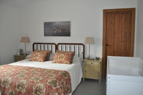 um quarto com uma cama e duas mesas de cabeceira com dois candeeiros em Casa rural La Liñana em Córdoba