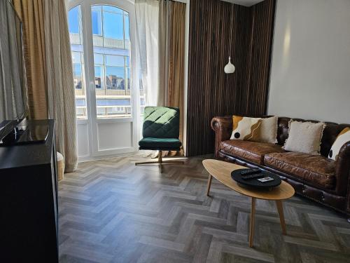 salon z brązową kanapą i stołem w obiekcie Appartement Fernand Namur w mieście Namur