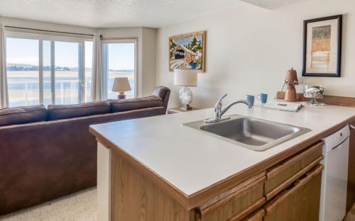 a kitchen with a sink and a living room with a couch at Dock of The Bay #203 in Lincoln City