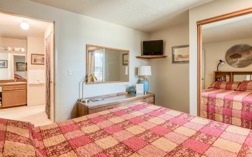 a bedroom with two beds and a sink and a mirror at Dock of The Bay #203 in Lincoln City