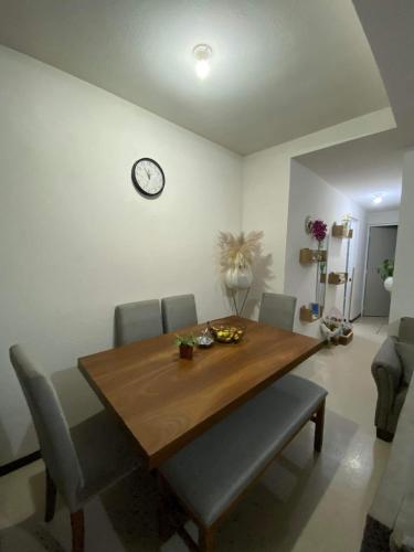 阿瓜斯卡連特斯的住宿－Casa para descanso，餐桌、椅子和墙上的时钟