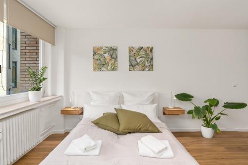 a white bedroom with a bed with two pillows at Studio-Apartment im Stadtzentrum in Bremen