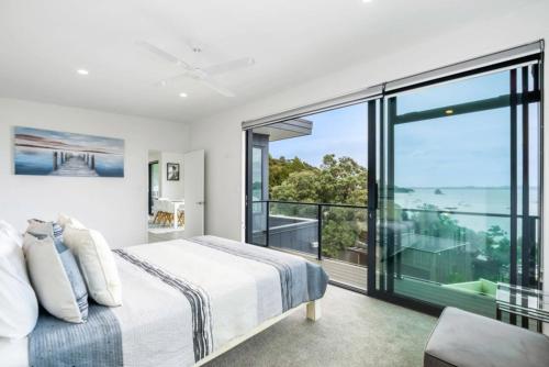 a bedroom with a bed and a large window at Bayview Apartment - Paihia Holiday Apartment in Paihia