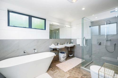 a bathroom with a tub and a sink and a shower at Bayview Apartment - Paihia Holiday Apartment in Paihia