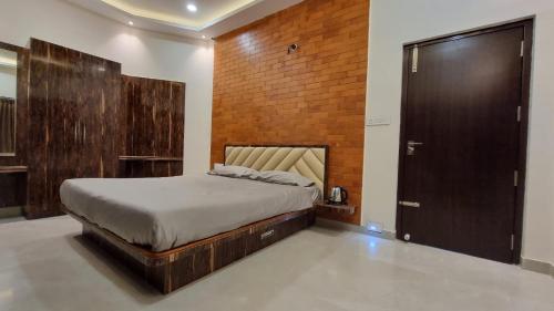 sypialnia z łóżkiem i ceglaną ścianą w obiekcie Melody Inn w mieście Yercaud