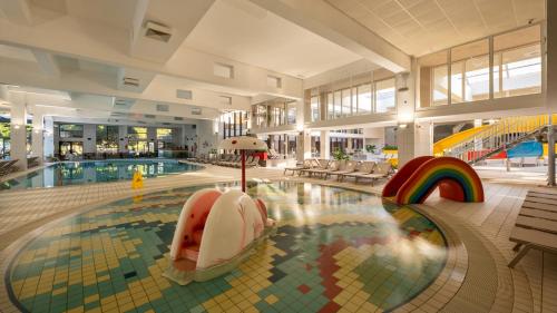 a large swimming pool with a rainbow in a building at Mobile Homes Terme Jezercica in Donja Stubica