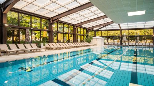 a large swimming pool with chairs and a building at Mobile Homes Terme Jezercica in Donja Stubica
