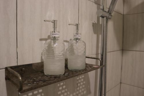 dos botellas de leche sentadas en un estante en un baño en BALE DATU BUNGALLOW, en Gili Trawangan