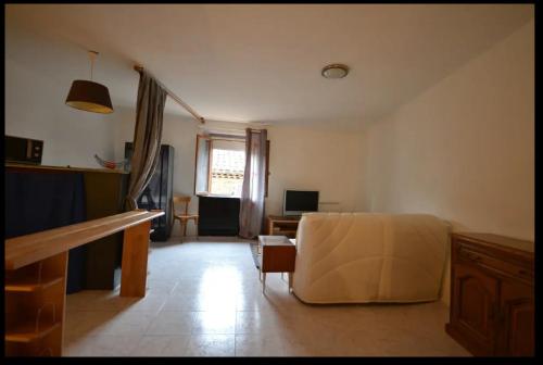 un salon avec un canapé, une table et une télévision dans l'établissement Studio VILLAGE 2ème étage, à Entrecasteaux