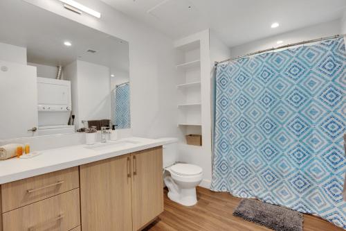 baño con aseo y cortina de ducha azul en Apart Hotel at Chinatown en Los Ángeles