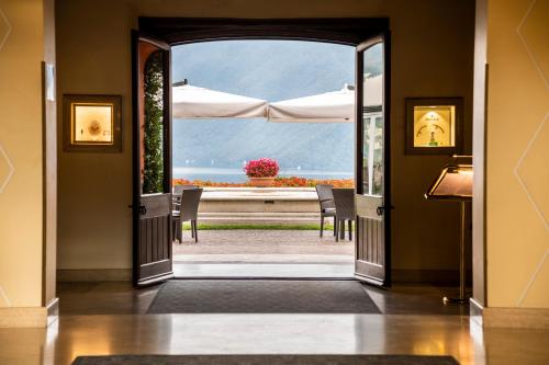 una porta aperta su un patio con vista sull'oceano di Villa Principe Leopoldo - Ticino Hotels Group a Lugano