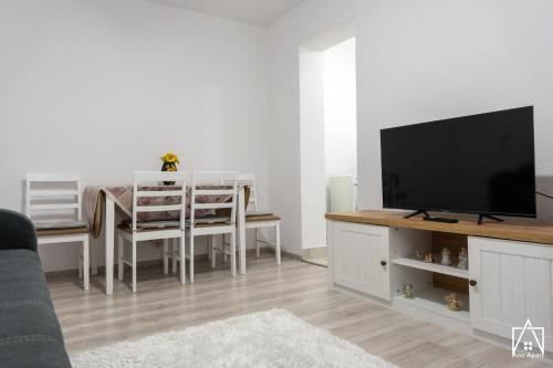ein Wohnzimmer mit einem TV und einem Esstisch in der Unterkunft Ana Apart in Gheorgheni