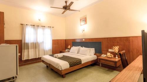 um quarto com uma cama e uma ventoinha de tecto em Woodlands em Bangalore