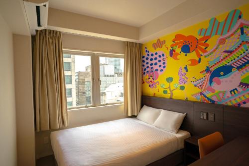 大阪市にあるLub d Osaka Honmachiの壁画が飾られた部屋のベッド1台
