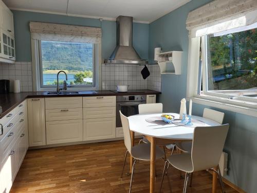 - une cuisine avec une table, des chaises et un évier dans l'établissement Idyllisk hus med sauna og jacuzzi, Lyngen, à Nord-Lenangen