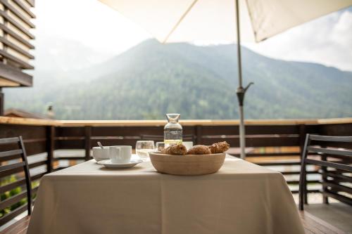 a table with a bowl of food on a table with an umbrella at Pöder - daheim in den Bergen in Ultimo
