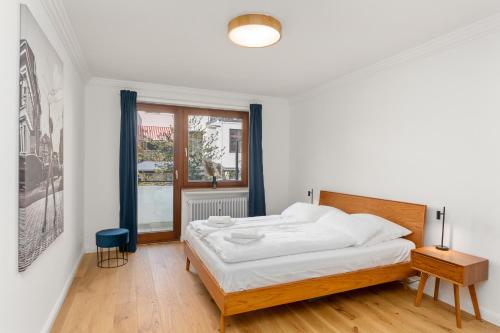 ein weißes Schlafzimmer mit einem Bett und einem Fenster in der Unterkunft Modern Oak-Apartment für bis zu 6 Personen in Bremen