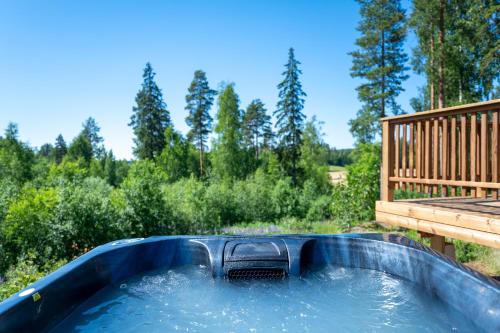 a hot tub with a deck and water at Himoskuutio 3 in Jämsä