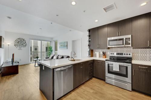 a kitchen with stainless steel appliances and wooden cabinets at Apart Hotel at Chinatown in Los Angeles