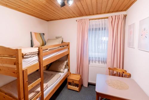 a bedroom with two bunk beds and a table at Auszeit-Hof Südburgenland in Neuhaus am Klausenbach