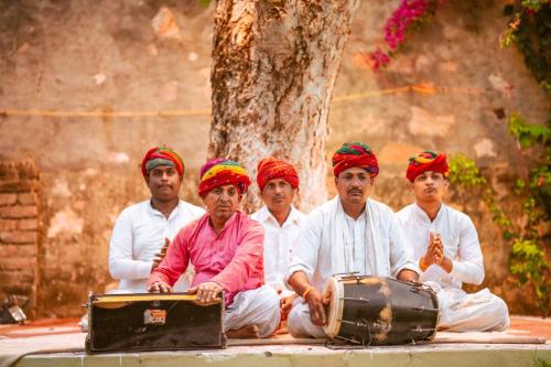 a group of men sitting on the ground with drums at RajBagh by Aaryam in Sawāi Mādhopur