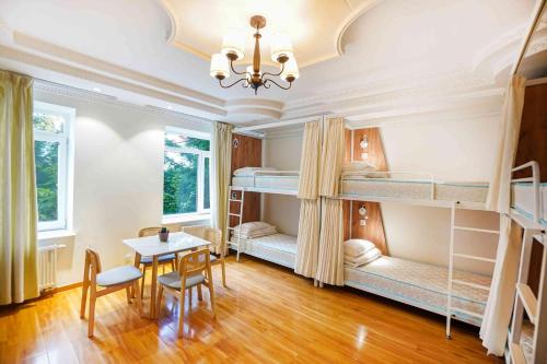 a room with two bunk beds and a table and chairs at White hostel Mongolia in Ulaanbaatar