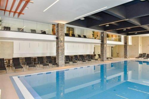 a large swimming pool with chairs in a building at Zlatiborski konaci k14/3 in Zlatibor