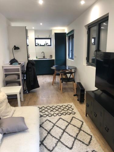 un salon avec un canapé blanc et une table dans l'établissement la maison des vignes, à Bordeaux