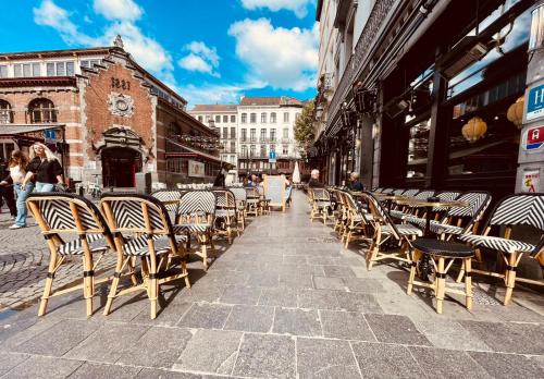 uma fila de mesas e cadeiras numa rua da cidade em Boutique Hotel Saint-Géry em Bruxelas