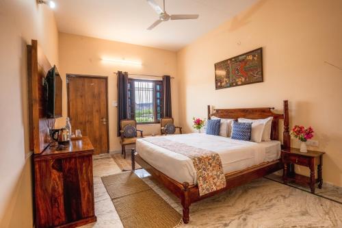 a bedroom with a bed and a flat screen tv at RajBagh by Aaryam in Sawāi Mādhopur