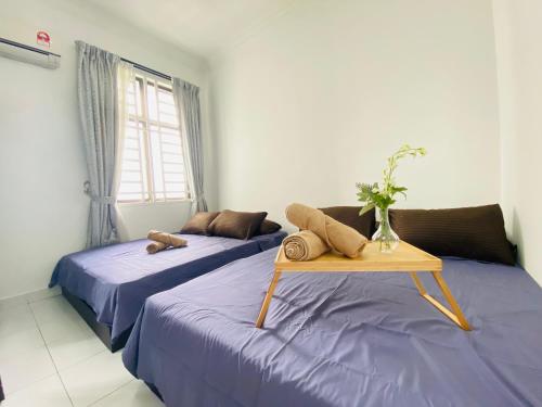 two beds in a room with a table between them at Cozy 1-10 pax 4QBeds 2SBeds Shah Alam Sec7, I-city in Shah Alam
