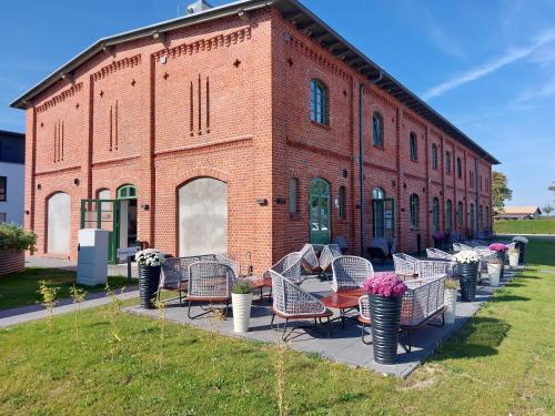 a group of chairs sitting outside of a brick building at SEA YOU in Klink
