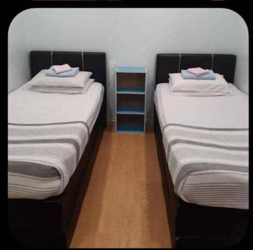 two beds sitting next to each other in a room at SC Lodging House Sinsuran Complex in Kota Kinabalu