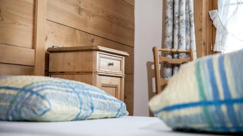 a pillow sitting on top of a bed with a chair at Hotel Badhof in Altstätten
