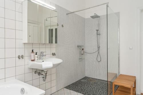 a white bathroom with a sink and a shower at Jugendstil-Traumwohnung direkt am Weserstadion in Bremen