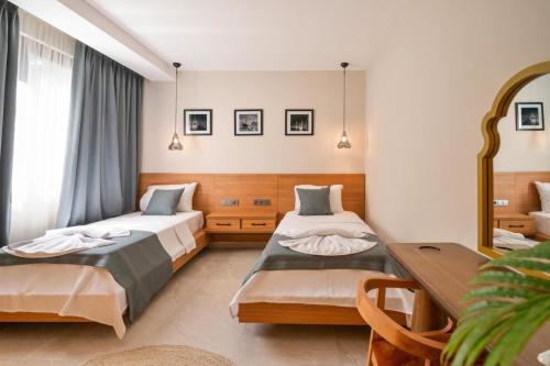 a hotel room with two beds and a table at Villa Bianca with Sea View in Ovacik