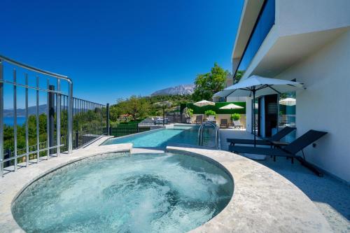 una piscina junto a un edificio con sombrilla en Villa Bianca with Sea View en Ovacik